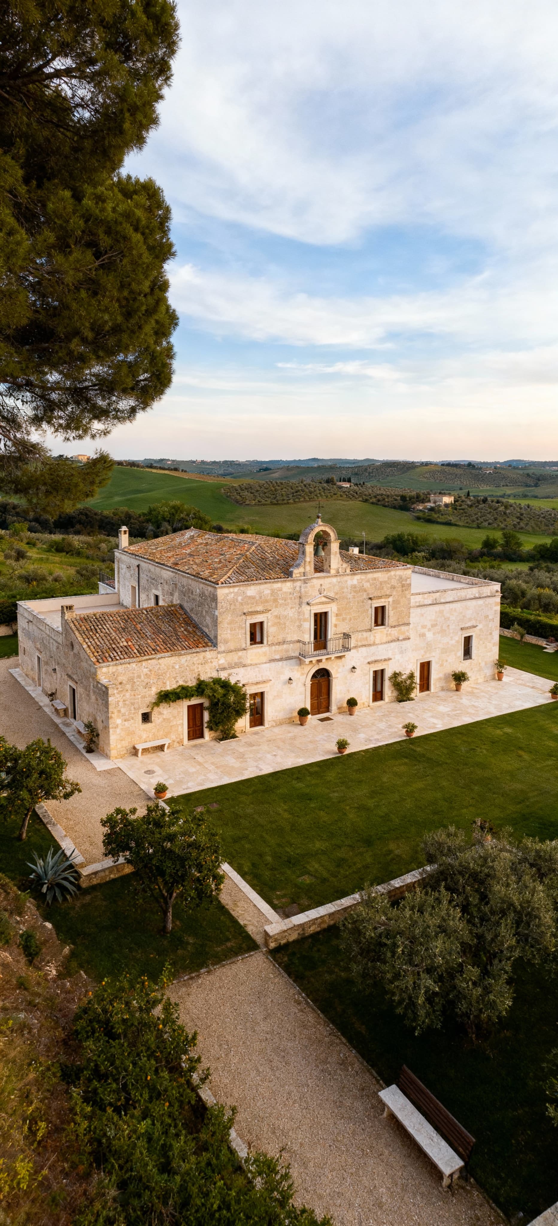 Masseria storica in Puglia immerse nel verde, con interni eleganti, sotto un cielo sereno e in un paesaggio idilliaco.